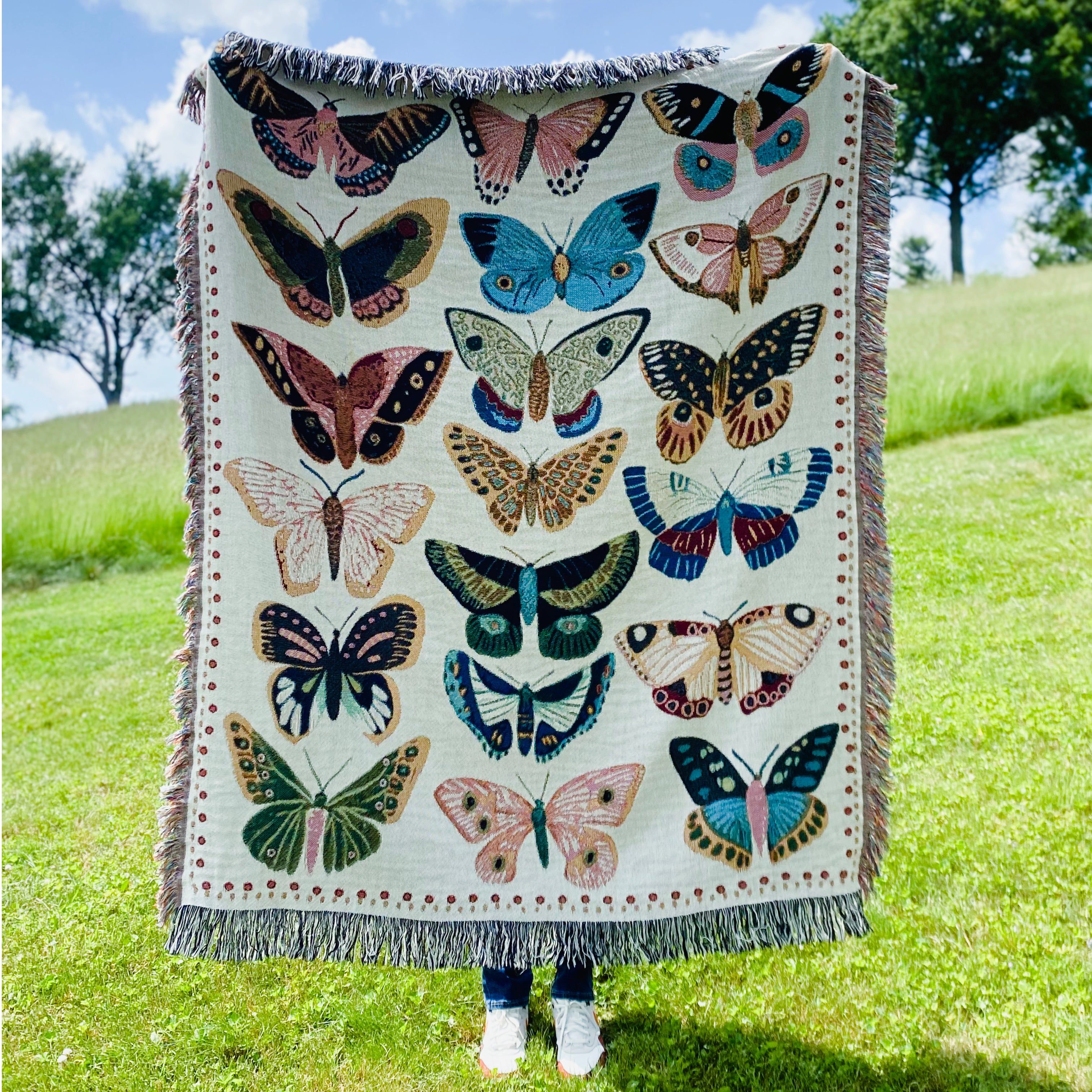 Woven blanket of Hand-drawn butterflies and moths in whimsical multicolor array. Sweet joyful design fills spaces with organic vibes.