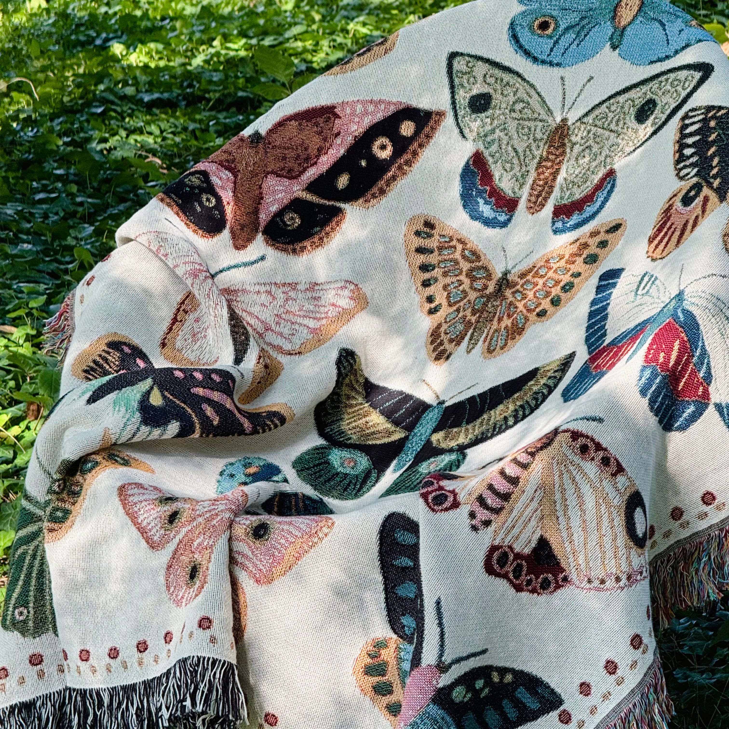 Woven blanket displaying array of butterflies in coral pink, bright turquoise, sunshine yellow, forest green, and rust orange creating joyful multicolor celebration