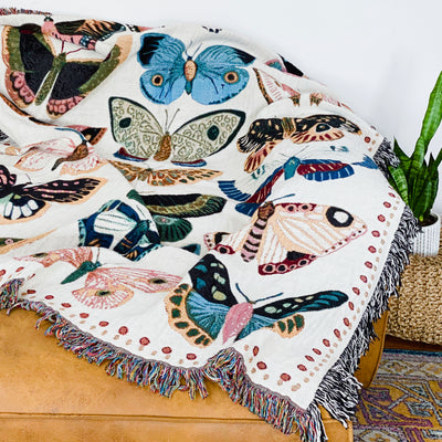 Woven blanket displaying array of butterflies in coral pink, bright turquoise, sunshine yellow, forest green, and rust orange creating joyful multicolor celebration