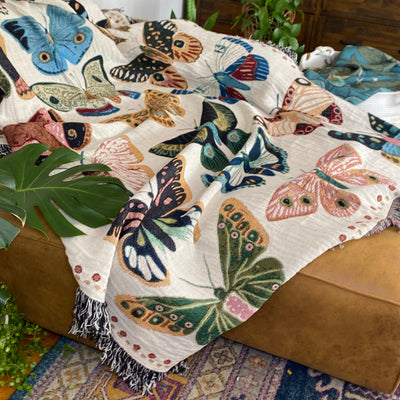 Woven blanket of Hand-drawn butterflies and moths in whimsical multicolor array. Sweet joyful design fills spaces with organic vibes.