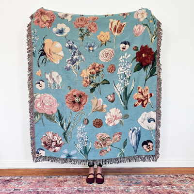 Woven blanket of pressed-flower botanicals scattered on soft robin's egg blue: roses, tulips, pansies, poppies, irises and hyacinths in blush, cream, red and peach. Nostalgic and romantic, like flowers kept between the pages of a favorite book. It can be personalized. The Vintage Garden.